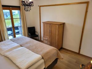ein Schlafzimmer mit einem Bett, einer Kommode und einem Fenster in der Unterkunft Villa Hubertus in Feldberg