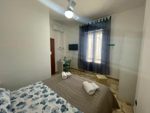 a bedroom with a bed with two towels on it at Casa Vacanze J&F in Pozzallo