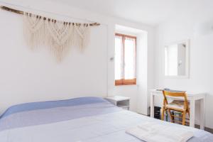 - une chambre blanche avec un lit et un bureau dans l'établissement Banchi, à Riomaggiore