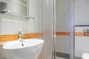 La salle de bains est pourvue d'un lavabo blanc et d'une douche. dans l'établissement Banchi, à Riomaggiore