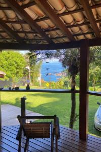 uma vista para o oceano a partir do alpendre de uma casa em Chales Sea Sul em Ilhabela