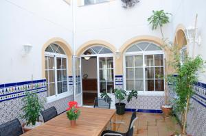 pokój ze stołem, krzesłami i oknami w obiekcie Casa del Patio Andaluz w Maladze