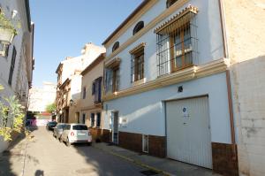 un coche blanco aparcado en una calle al lado de un edificio en Casa del Patio Andaluz, en Málaga