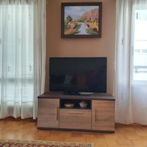 a flat screen tv on a wooden entertainment center in a living room at Piso amplio en el centro de Vilagarcía de Arousa in Vilagarcia de Arousa