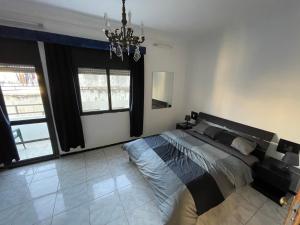 Un dormitorio con una cama grande y una lámpara de araña. en Apart familiar bab okla, en Tetuán