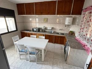 una pequeña cocina con mesa blanca y sillas en Apart familiar bab okla, en Tetuán