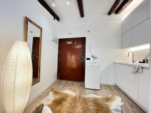 a kitchen with white cabinets and a brown door at Encantador Tirso Molina Exterior Mesón in Madrid