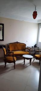 a living room with a couch and a table at Appartement Amilcar in Dar Salah Bey