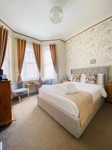 a bedroom with a large white bed and a couch at Coastal Waters (Hotel Barton) in Torquay