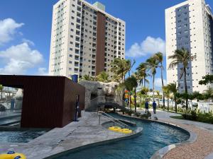 a swimming pool in a city with two tall buildings at Salinas Premium Resort 2Q in Salinópolis