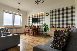 a living room with a couch and a table at ENERGYLANDIA Zator Apartament Asia in Zator