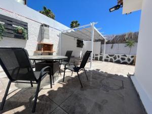 een patio met een tafel en stoelen en een grill bij The Yumbo Pearl in Playa del Inglés