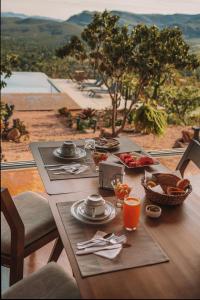 - une table en bois avec de la nourriture sur le balcon dans l'établissement Vila Toá, à Alto Paraíso de Goiás