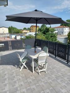 einen Tisch und zwei Stühle mit Sonnenschirm auf einer Terrasse in der Unterkunft Alessietto in Verona