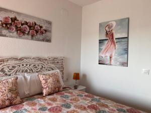 a bedroom with a bed and a painting on the wall at Estudios Costavigía Mazagón by Ramona in Mazagón