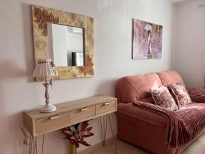 a living room with a couch and a mirror at Estudios Costavigía Mazagón by Ramona in Mazagón