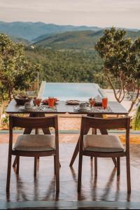 einen Tisch mit zwei Stühlen und eine Mahlzeit darauf in der Unterkunft Vila Toá in Alto Paraíso de Goiás