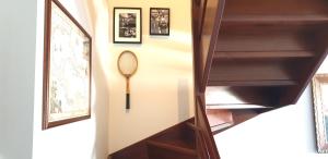 uma escadaria com uma raquete de ténis pendurada numa parede em Charming apartment & parking by ANTHEA HOMES em Grado