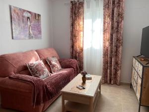 a living room with a brown couch and a table at Estudios Costavigía Mazagón by Ramona in Mazagón