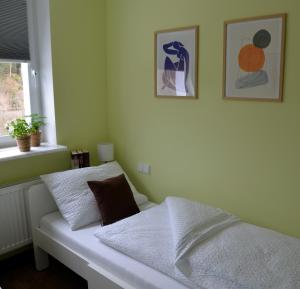 1 cama en un dormitorio con 2 cuadros en la pared en Am Quellenhäuschen, en Naila