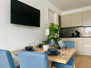 a dining room table with chairs and a television on the wall at Riverfront Apartment with Balcony and AC in Vienna