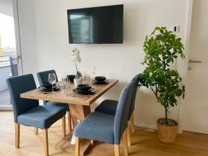 a dining room table with chairs and a potted plant at Riverfront Apartment with Balcony and AC in Vienna