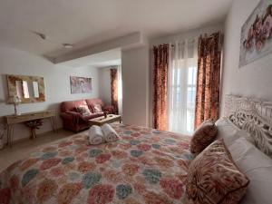 a bedroom with a large bed and a couch at Estudios Costavigía Mazagón by Ramona in Mazagón