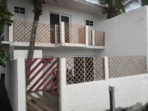 una casa blanca con una puerta y una valla en Villas Higuer, en Escuintla