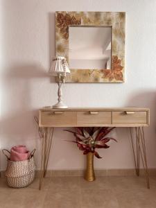 a dressing table with a mirror and a lamp at Estudios Costavigía Mazagón by Ramona in Mazagón
