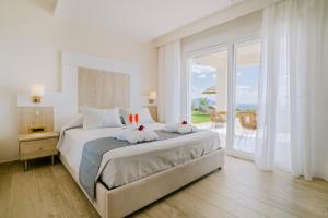 a bedroom with a large bed with a view of the ocean at The Three Graces in Antimácheia