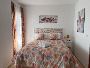 a bedroom with a bed with a comforter and pillows at Estudios Costavigía Mazagón by Ramona in Mazagón