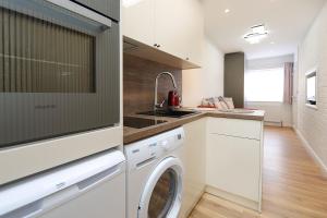 a kitchen with a washer and dryer at Peaceful and Novel Place to Stay in Abbey Wood