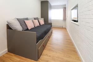 a bed with pink pillows on it in a room at Peaceful and Novel Place to Stay in Abbey Wood