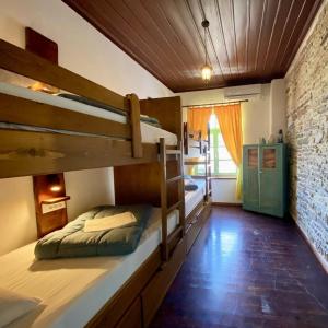 Zimmer mit 2 Etagenbetten und Ziegelwand in der Unterkunft Stone City Hostel in Gjirokastër