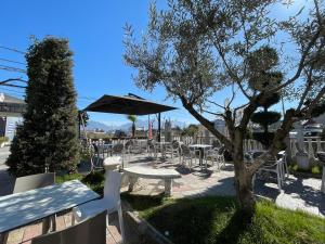 a group of tables and chairs with an umbrella at Vila 125 Apartments & Restaurant in Tirana