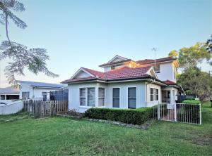 una casa blanca con una valla en un patio en Sydney Meets Miranda, Comfy 4 Bedrooms Corner House, en Miranda