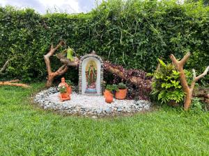 un jardin avec un sanctuaire et des plantes dans l'herbe dans l'établissement Casa Campestre Sol Naciente, à La Tebaida