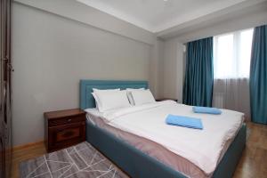 um quarto com uma cama grande e uma cabeceira azul em Spacious central apartment em Almaty