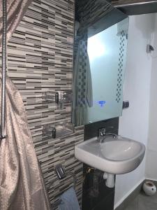 un bagno con lavandino e specchio di appartement Lalla ghita essaouira a Essaouira
