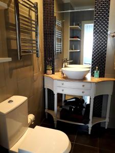 uma casa de banho com um lavatório branco e um WC. em Casa de Leça em Leça da Palmeira
