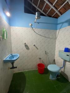 a bathroom with a sink and a toilet and a shower at Castello's Coco Huts in Benaulim