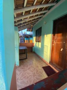 ein leeres Zimmer mit einer Bank und einer Tür in der Unterkunft Castello's Coco Huts in Benaulim