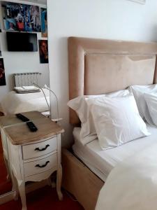 a bedroom with a bed and a nightstand with a phone on it at Casa de Leça in Leça da Palmeira