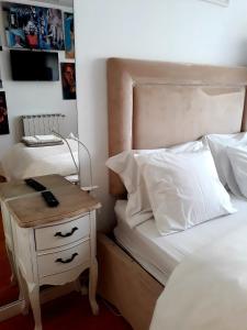 - une chambre avec un lit et une table de chevet avec un téléphone dans l'établissement Casa de Leça, à Leça da Palmeira