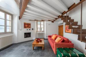 a living room with a red couch and a table at Cozy Suites on the Lake - The House Of Travelers in Brienno