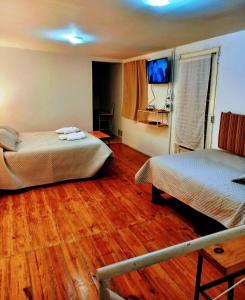 Habitación de hotel con 2 camas y TV en Mi casa, Su casa en Salta