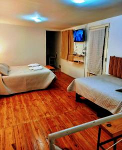 a hotel room with two beds and a television at Mi casa, Su casa in Salta