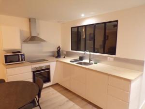 a kitchen with a sink and a microwave at Appartement 2/4 pers, 44m2, hypercentre. in Lons-le-Saunier