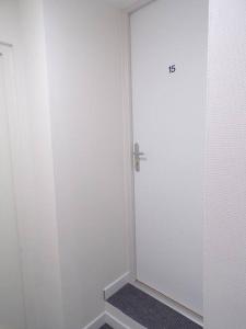 La salle de bains est pourvue d'une porte blanche et de carrelage. dans l'établissement Appartement 2/4 pers, 44m2, hypercentre., à Lons-le-Saunier