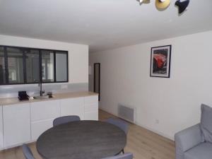 a living room with a table and a chair at Appartement 2/4 pers, 44m2, hypercentre. in Lons-le-Saunier